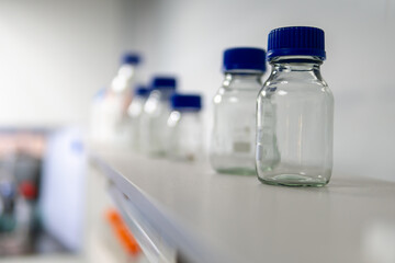Empty medical glass and plastic jars on the shelf, selective focus, liquid containers. pharmaceuticals oriental pharmacy. Copy space