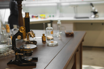 Vintage old microscope on table for science background. Medicine, alchemy, pharmacist. glass jars,...
