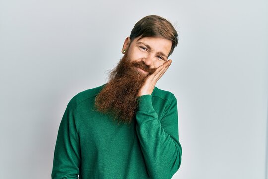 Redhead man with long beard wearing casual clothes thinking looking tired and bored with depression problems with crossed arms.