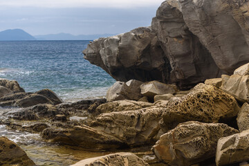 Felsen in der Bucca delle Fate mit Blick Richtung Isola del Elba, Toskana, Italien mit Wolken und...