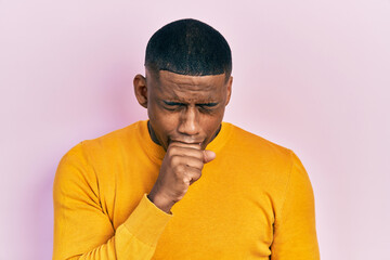 Fototapeta premium Young black man wearing casual yellow sweater feeling unwell and coughing as symptom for cold or bronchitis. health care concept.