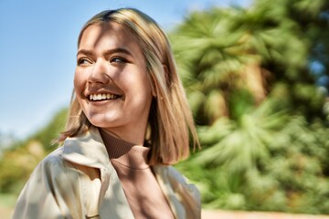 Young blonde girl smiling happy standing at the city.