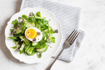 Fresh cucumber salad with micro greens and egg. Trending food. Top view, flat layout,