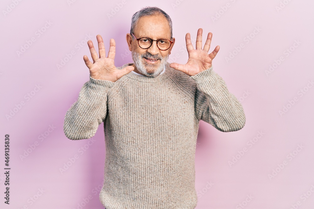 Sticker handsome senior man with beard wearing casual sweater and glasses showing and pointing up with finge