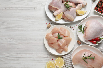 Flat lay composition with fresh raw chicken meat on white wooden table. Space for text