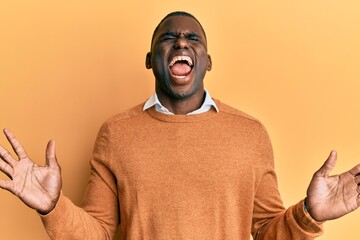 Young african american man wearing casual clothes celebrating mad and crazy for success with arms...