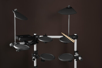 Fototapeta na wymiar Modern electronic drum kit with sticks on brown background. Music instrument