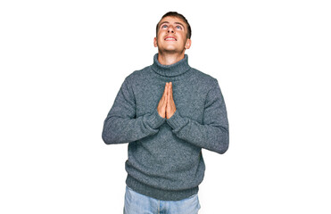 Young blond man wearing casual clothes begging and praying with hands together with hope expression on face very emotional and worried. begging.