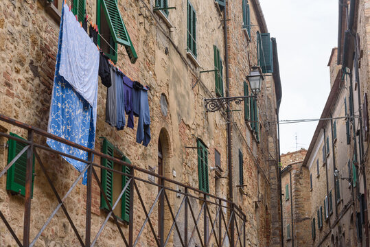 Fassaden mit Fenster, Fensterl&auml;den und W&auml;sche,  Himmel und Wolken in Italien, Volterra

