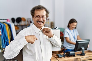 Southeast asian man wearing holding shopping bags pointing finger to one self smiling happy and proud
