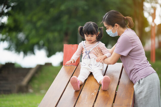 Young Asian Mother Playing With Her Baby On The Playground. Mom And Daugther. Cute Baby Daugther Playing With Mom Happy Funny Family Concept