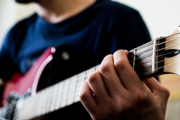 Bottom view of an unrecognizable man playing an electric guitar. Highly contrasted,view from the...