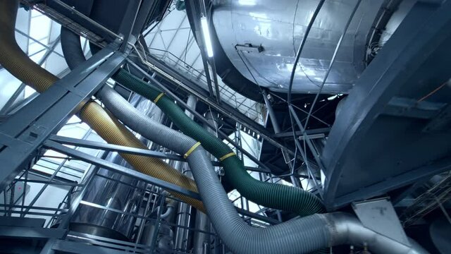 New metal industry inside. Dairy production plant with stainless tubes. Interior of modern milk factory. View from below.