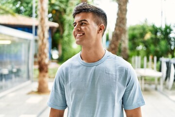 Young hispanic man smiling confident standing at street