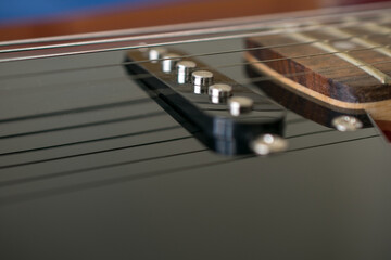 Close-up detail of the pickup of an electric guitar. They are transducers that capture the...