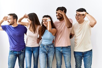 Group of young people standing together over isolated background very happy and smiling looking far...