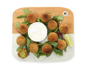 Delicious falafel balls with herbs, lime and sauce on white background, top view
