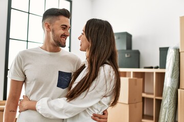 Young hispanic couple smiling happy and hugging at new home.