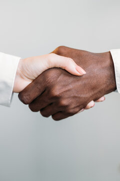 Diverse handshake. Gender equality. International partnership. Deal agreement. Closeup of multiracial business people shaking hands isolated on neutral.
