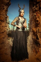 Mysterious woman sorcerer ready to fight in ruins by sword and spell