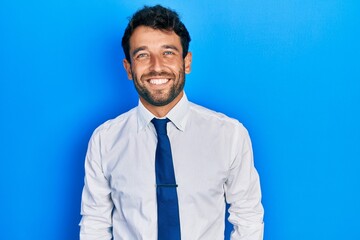 Handsome man with beard wearing business shirt and tie with a happy and cool smile on face. lucky...