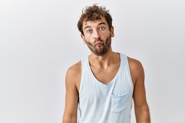 Young handsome man standing over isolated background making fish face with lips, crazy and comical gesture. funny expression.