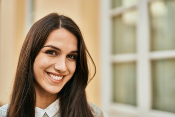 Young hispanic woman smiling happy standing at the city.