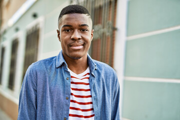 Obraz premium Young african american man smiling happy standing at the city.