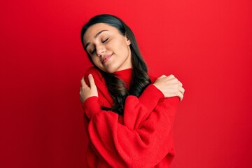 Young hispanic woman wearing casual clothes hugging oneself happy and positive, smiling confident. self love and self care