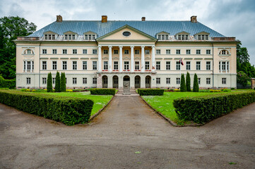 Fototapeta na wymiar View to Kazdanga Palace built in the late classical style. The road leads to the entrance of palace. Latvia. Baltic.