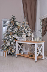 The interior of the Christmas room. Christmas tree, table with candles near the mirror. New Year decorations and mood!