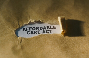 Torn paper in the middle of the sheet, inside on a white background the inscription - AFFORDABLE CARE ACT