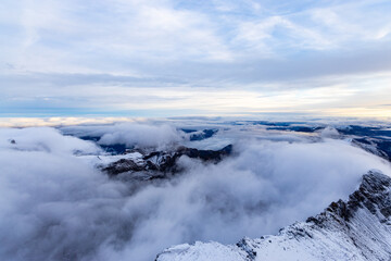 View from the summit of mountain Schilthorn in the Swiss Alps Switzerland at sunrise with dramatic clouds and fresh snow.