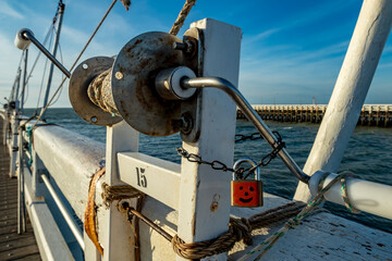 Red painted lock on fishing equipment with smiley emoticon. Belgium