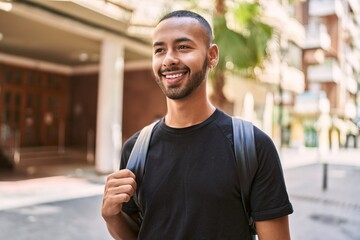 Young african american man smiling confident wearing backpack at street