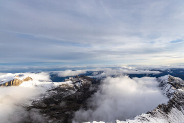 View from the summit of mountain Schilthorn in the Swiss Alps Switzerland at sunrise with dramatic clouds and fresh snow.
