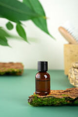 Glass bottle with tea tree essential oil standing on the bark of a tree. Cosmetic essence. Fresh...