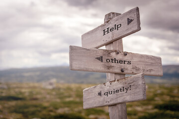 help others quietly text on wooden sign outdoors in nature. Religious and christianity quotes.