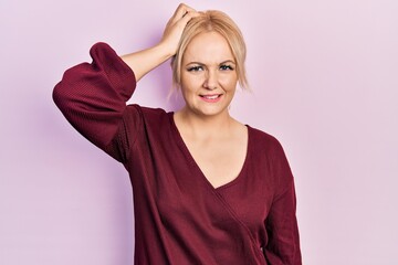 Young blonde woman wearing casual winter sweater confuse and wonder about question. uncertain with...