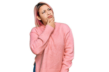 Hispanic woman with pink hair wearing casual winter sweater thinking worried about a question, concerned and nervous with hand on chin