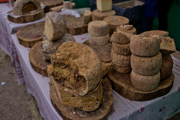 Presentation of various types of round cheeses. An open-air street fair stand. Ukraine.