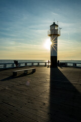 Light diffraction. Lighthouse, Nieuwpoort or Nieuport, Belgium. People silhouettes