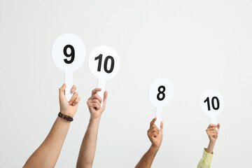 Panel of judges holding different score signs on white background, closeup