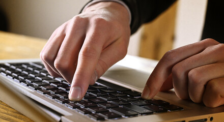 Business man typing on keyboard laptop in office. 