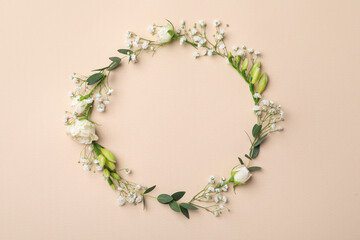 Frame made of beautiful gypsophila, roses, eucalyptus and freesia on beige background, top view. Space for text