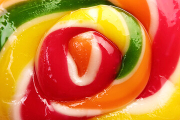 Sweet colorful lollipop on pink background, closeup view. Delicious candy
