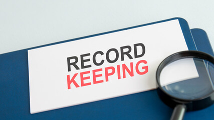 text record keeping on white paper card, black ahd red letters. lens on blue background. business...