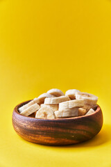  Bowl of slices of banana on a yellow background
