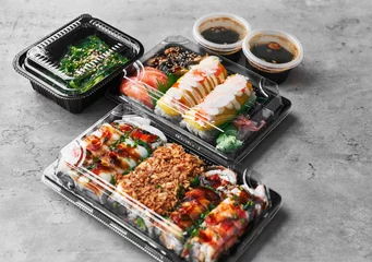 Fotobehang  Delivery tray of sushi food on a concrete surface © Krakenimages.com