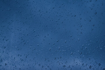 Abstract blurred background. Focus on the middle. Raindrops on the glass on a blue background....
